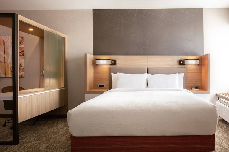 A design-forward guest room at SpringHill Suites by Marriott Ames with desk, modern art and headboard