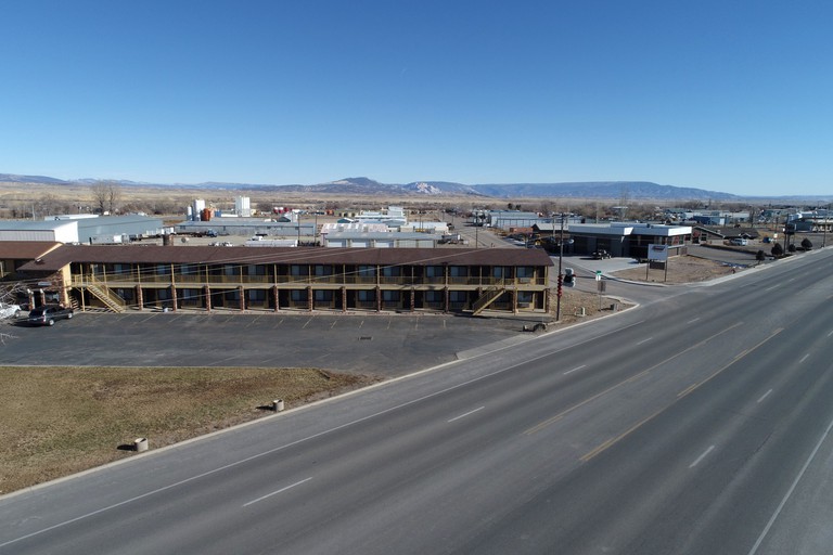An aerial view of the two-story Split Mountain Motel, with mountains in the distance