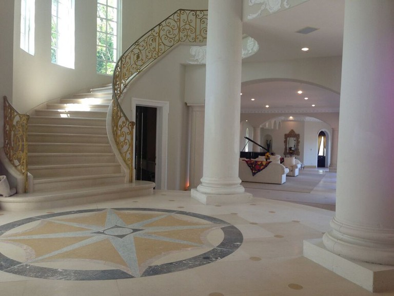 The grandiose foyer with columns and spiral staircase of the Stradella Court Mansion in Bel Air