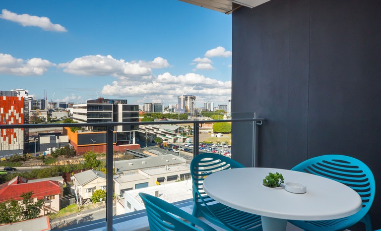 Balcony at Annexe Apartments, with blue chairs and city views