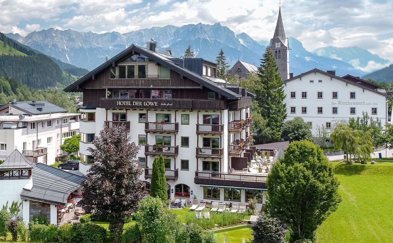 Hotel Der Löwe exterior with mountains behind