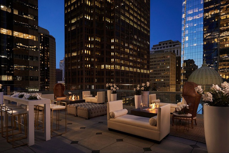 Rooftop terrace at Four Seasons Hotel Philadelphia at Comcast Center at dusk, surrounded by illuminated skyscrapers