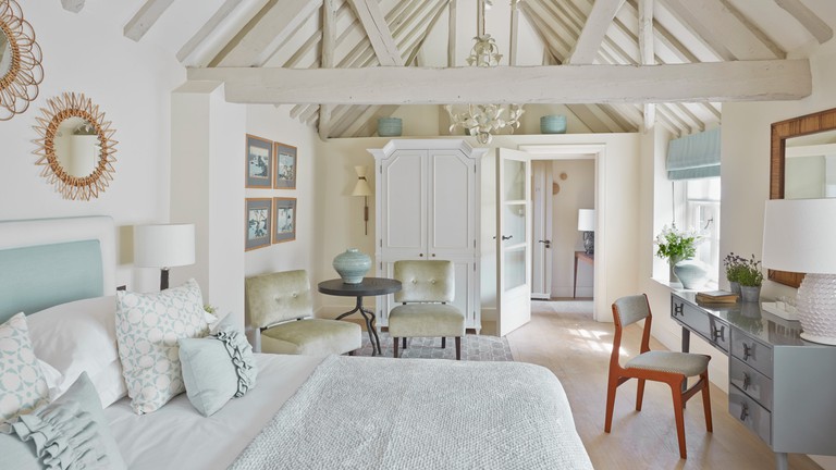 A neutral-toned room at Dormy House in the Cotswolds, including a double bed and much wooden furniture