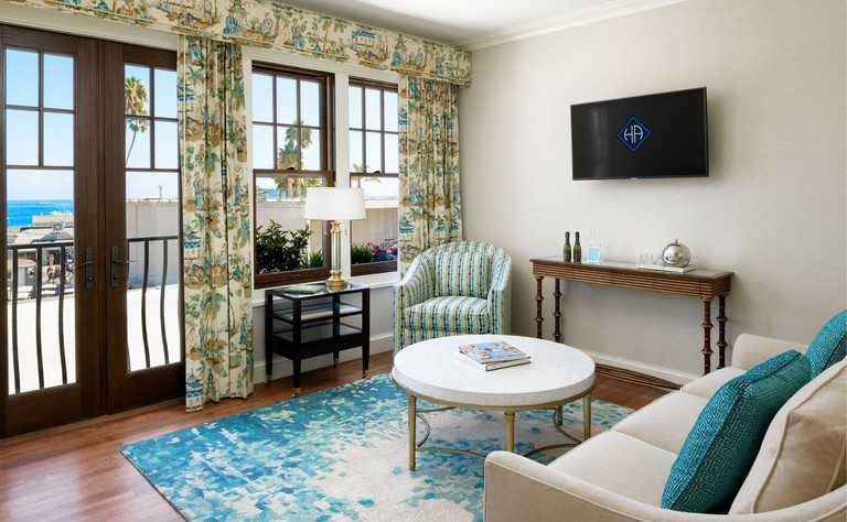 Luxury living room space in cream and aqua blue hues with view toward ocean at Hotel Atwater