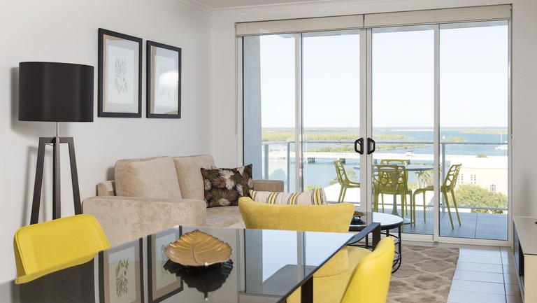 Bright living-diving area with sliding doors to balcony with river views at Riviera Mackay
