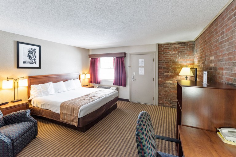 A spacious double guest room with exposed brick feature wall at the Eleven Boutique Hotel.