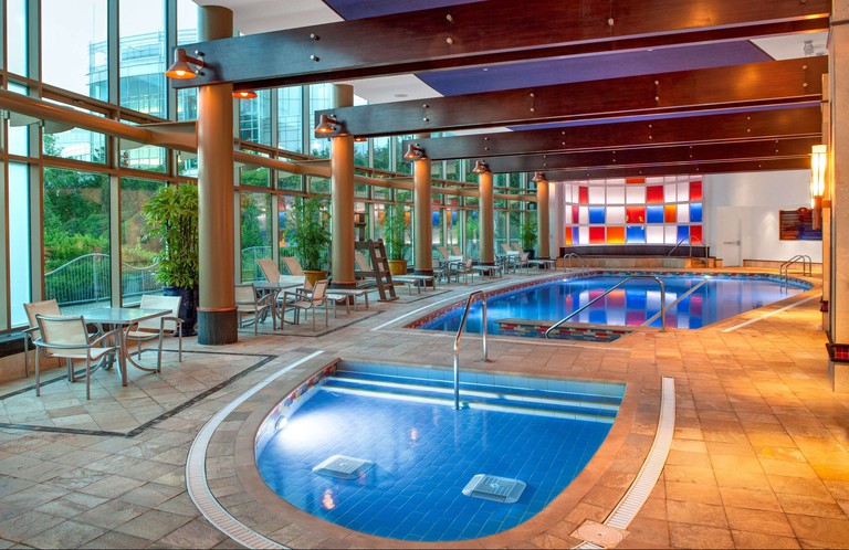 The indoor pool area at Hilton Lac-Leamy, with tables and chairs by the windows