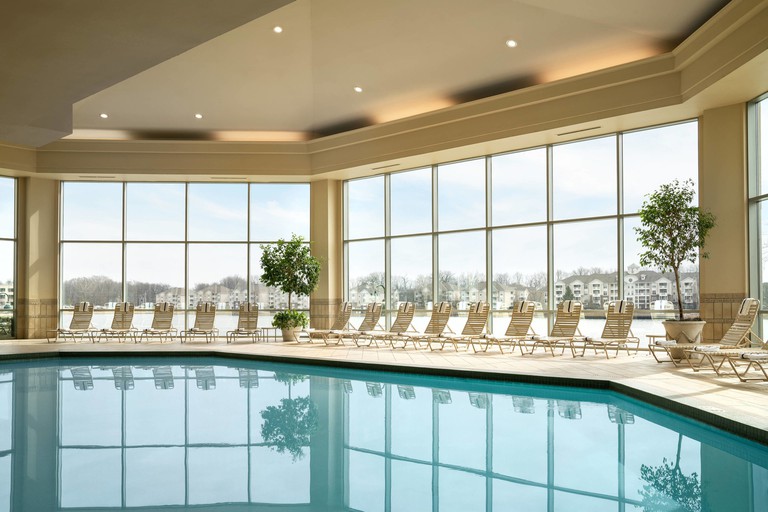 Indoor pool at the Marriott Indianapolis North, flanked by loungers and floor-to-ceiling windows