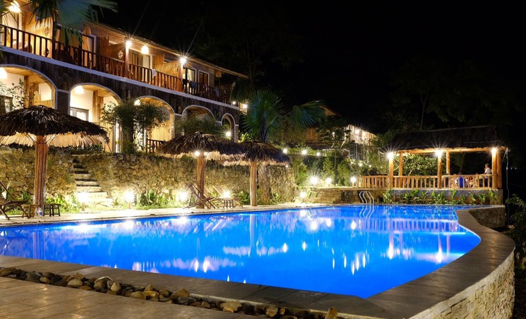 Rooms with balconies look over the infinity pool at Pu Luong Eco Garden, Vietnam, seen at night