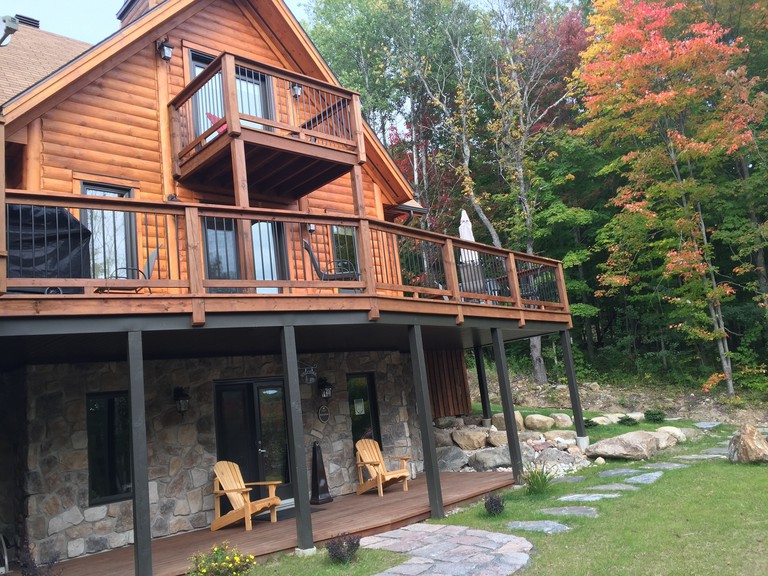 Wooden exterior of Selenia Lodge, Amherst with balcony and wooden chairs
