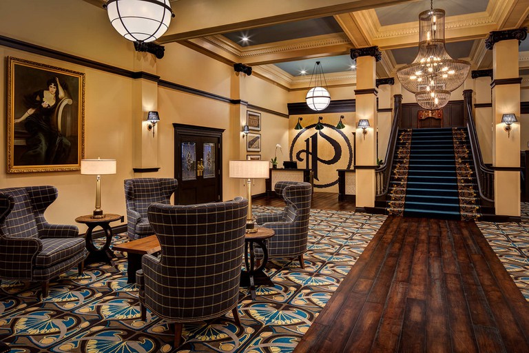 Opulent lobby with floral carpets and wooden panelling atThe Peery Hotel