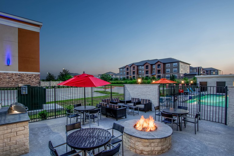 A romantic outside seating area at TownePlace Suites by Marriott Waco South with an open firepit