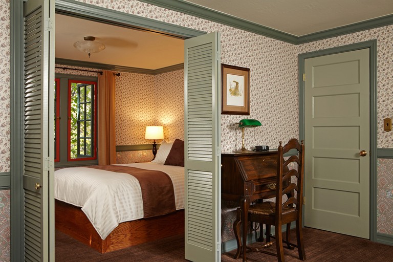 Room at UCLA Lake Arrowhead Lodge has simple design, wooden furniture and patterned wallpaper