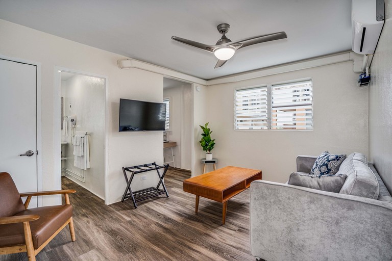 Aloha Suites Waikiki lounge with ceiling fan and wooden floor and sofa