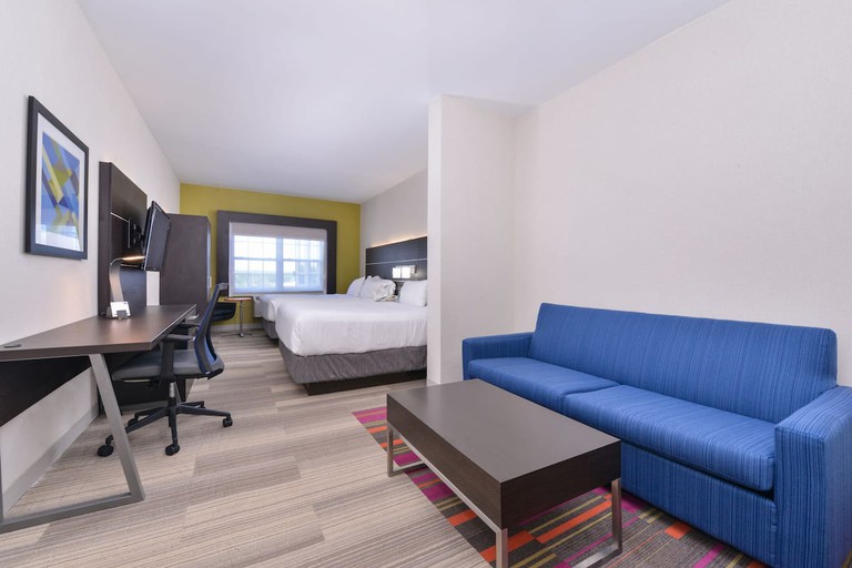 Large two-bed guest room with blue sofa and large desk at Holiday Inn Express Mystic