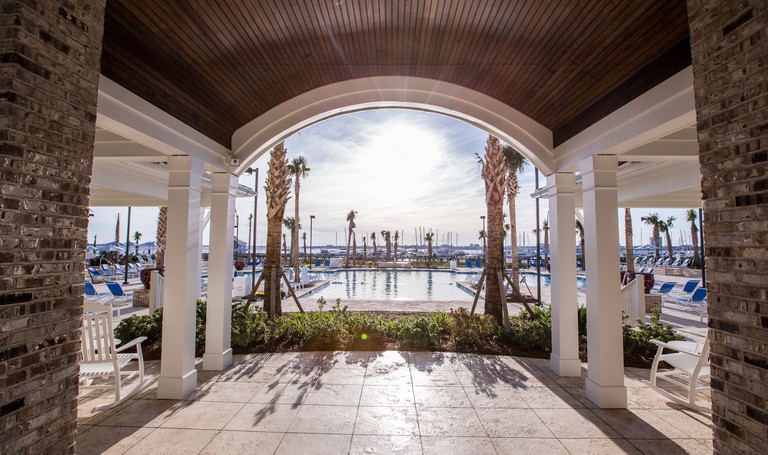 A covered outdoor sitting area with pool and marina views at the Beach Club at Charleston Harbor Resort and Marina