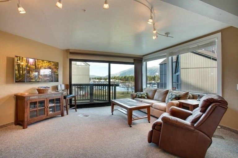 55 Tahoe Keys 6 living area with patio doors, flatscreen and leather sofa