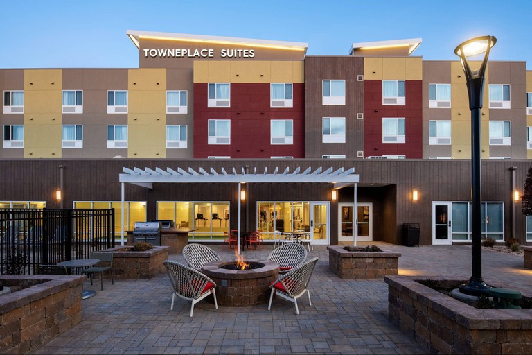 The exterior of TownePlace Suites by Marriott Twin Falls, with four chairs around a lit fire pit