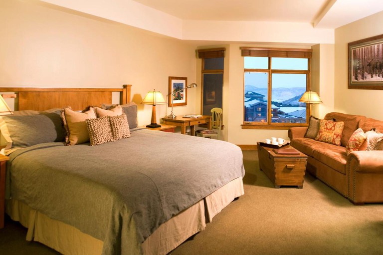 A double bed and a sofa with mountain views in a Sundial Lodge Park City room