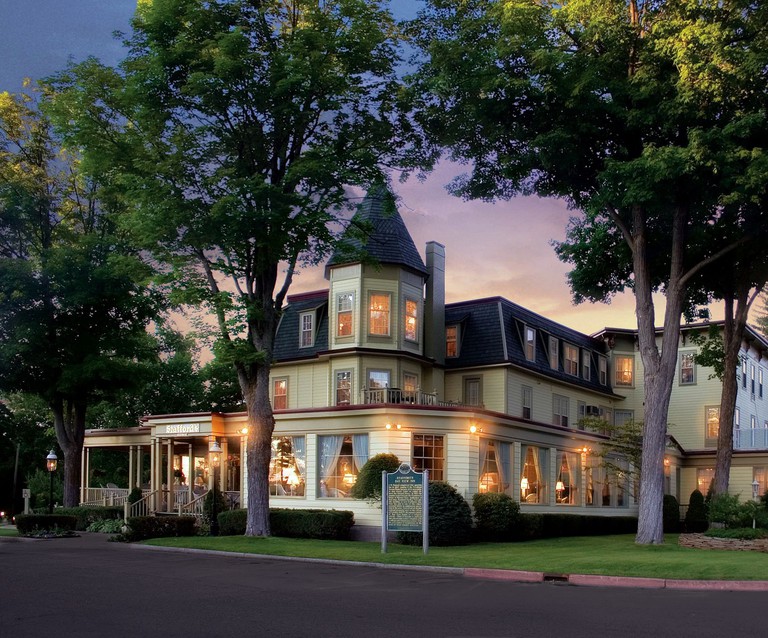 Outside view of the illuminated Stafford's Bay View Inn, surrounded by trees, at dusk
