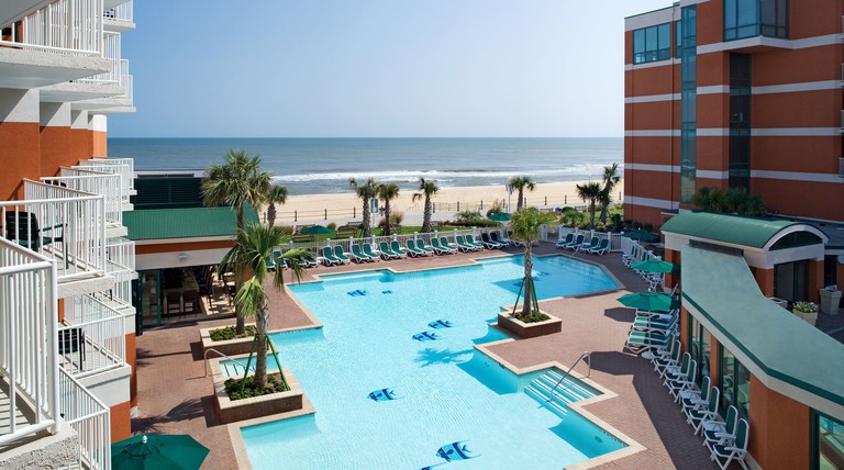 Beachfront outdoor pool with green sun loungers at Holiday Inn & Suites Virginia Beach