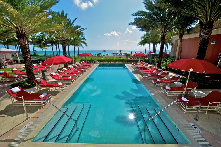 Acqualina Resort pool area with sea beyond and loungers