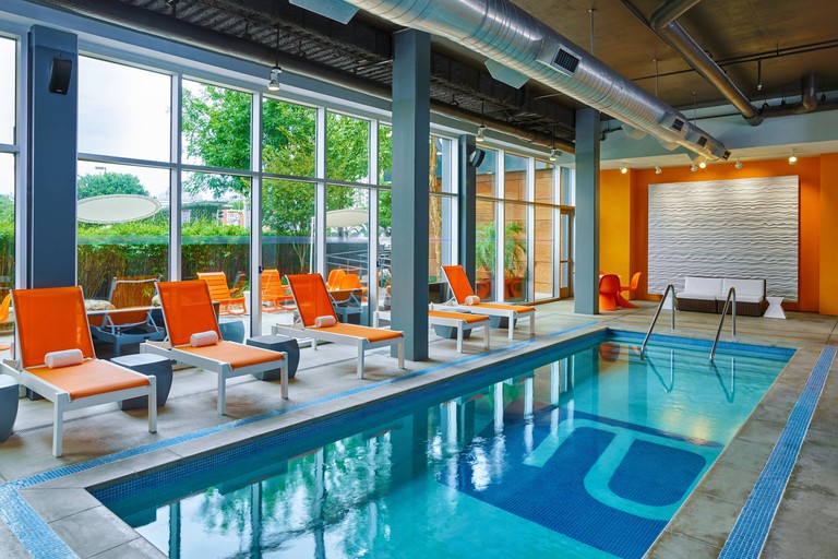 Aloft Omaha Aksarben Village indoor pool with loungers and floor to ceiling windows