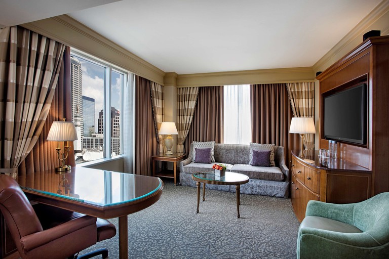 Conrad Indianapolis room in classic style with carpet, oak furniture and city view window