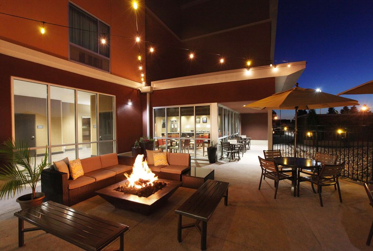 Outdoor terrace with patio furniture arranged around a firepit at DoubleTree by Hilton West Fargo