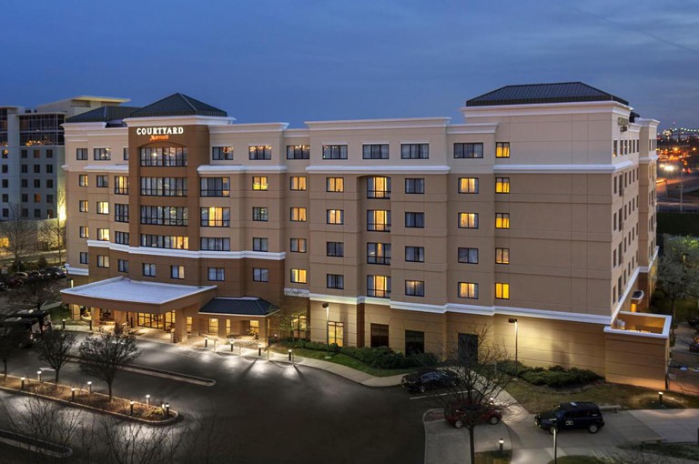 Exterior of Courtyard Newark Elizabeth has a large parking area, trees, modern lighting and a large modern building