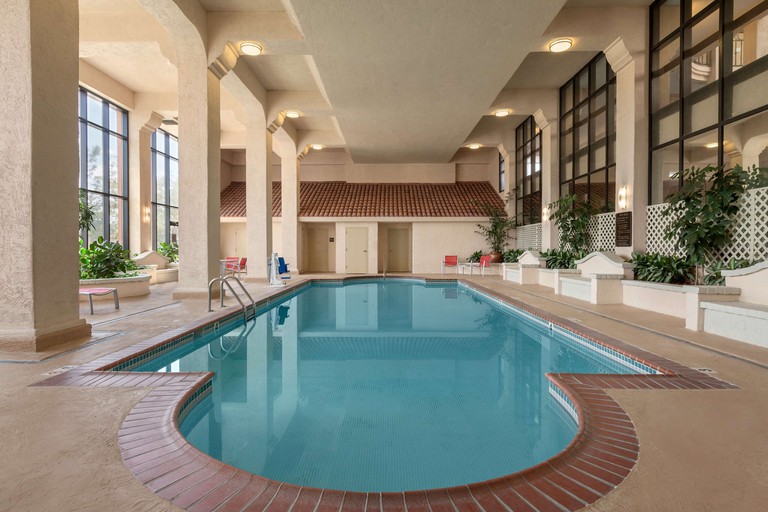 Indoor swimming pool in room decorated in beige and terracotta at Embassy Suites by Hilton Baton Rouge