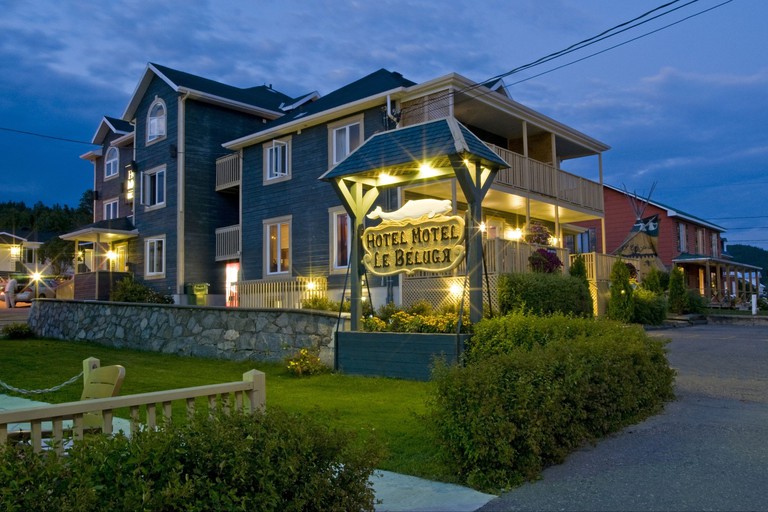 Le Beluga exterior with sign at dusk with lawns in front