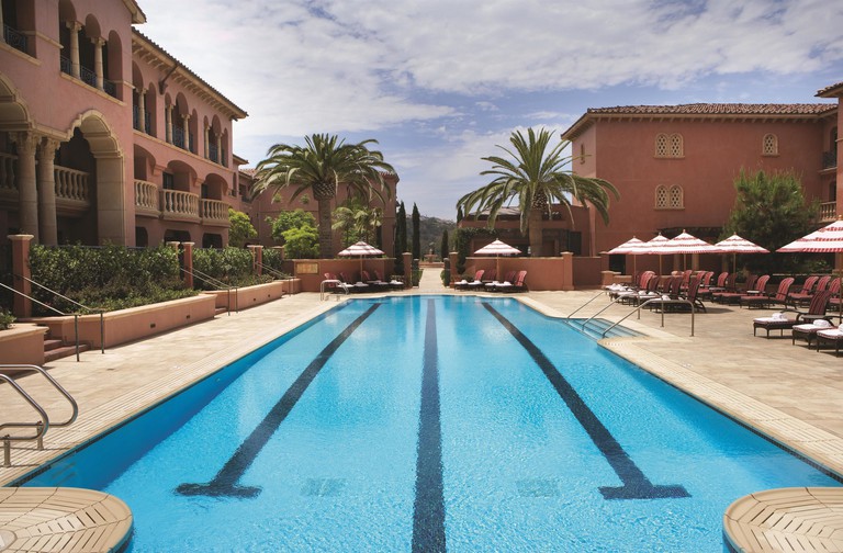 Fairmont Grand Del Mar outdoor pool with palms and loungers with umbrellas