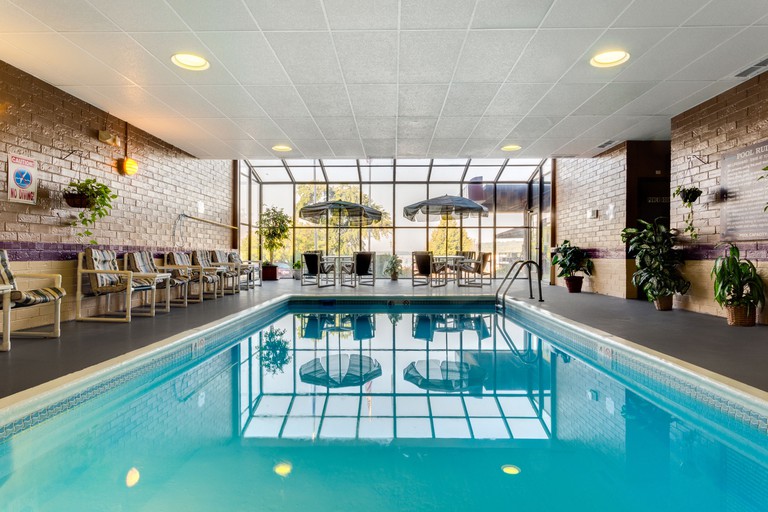 The indoor pool area at Harbor Shores on Lake Geneva, with a handrail, seats and large glass window