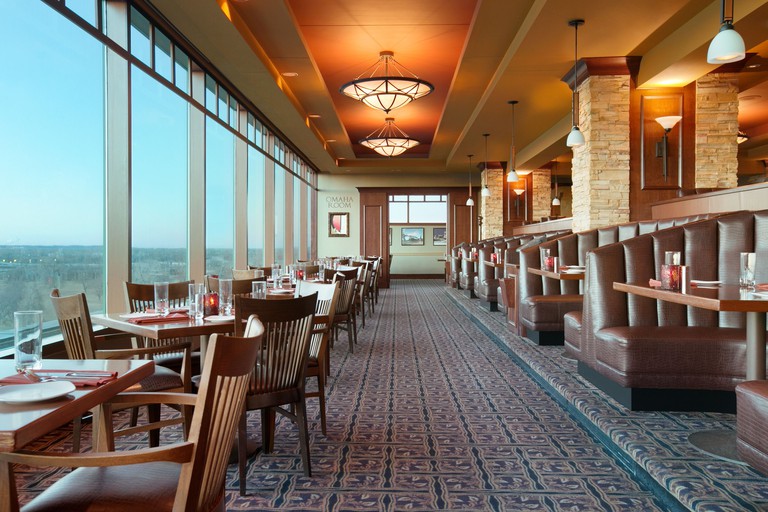 Numerous dining tables and chairs with parkland views from windows at Harrah's Casino and Hotel
