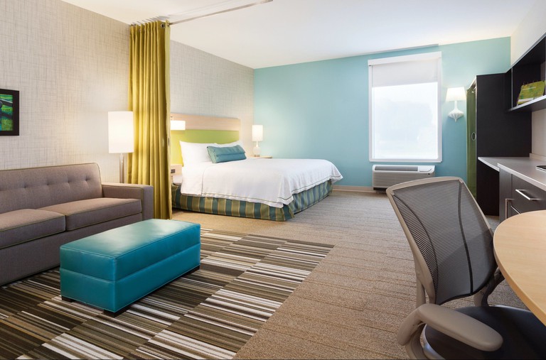 Suite at the Home2 Suites by Hilton Amarillo, decorated in grey tones, with colorful turquoise and lime green accents