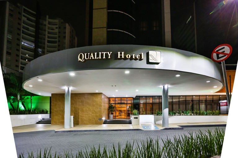 The exterior entrance to Quality Hotel with a curved roof featuring the hotel's name