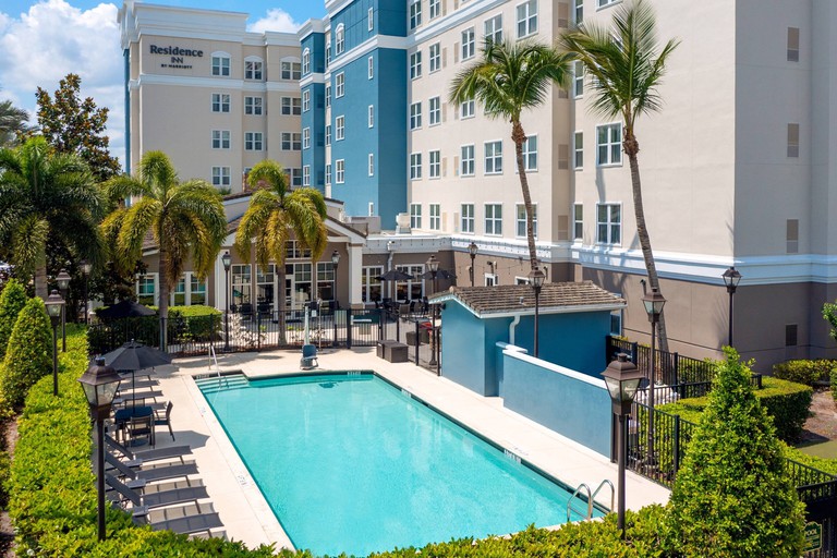 Outdoor swimming pool surrounded by sunbeds beside the main building of Residence Inn by Marriott
