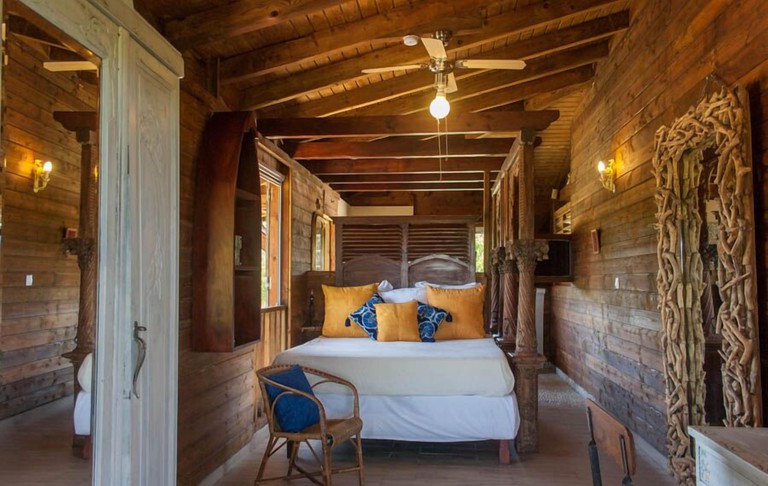 Bedroom in a wooden villa with a four-poster double bed at Residence Villa Zen