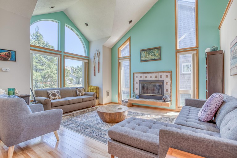 Living room at Sand Dollar Find with high ceilings, turquoise walls and grey sofas