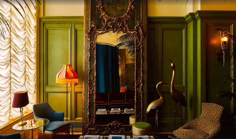 Ornate mirror by soft chairs in a room at the Siren Hotel