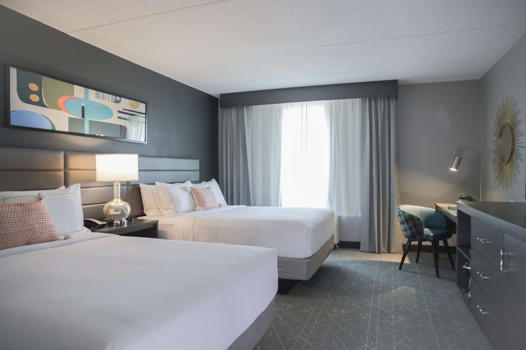 A stylish guest room with colorful art at the Rewind West Des Moines, Tapestry Collection by Hilton