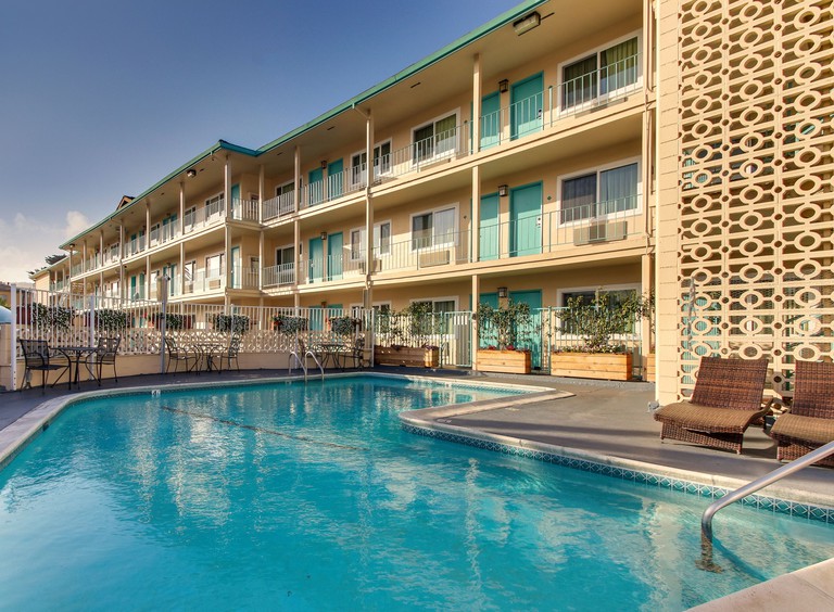 Exterior view of the Stevenson, Monterey, with three tiers of cream-colored balconies overlooking the swimming pool.