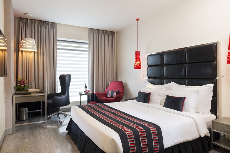 Aauris room with modern decor including leather headboard, wood floors and design light fittings