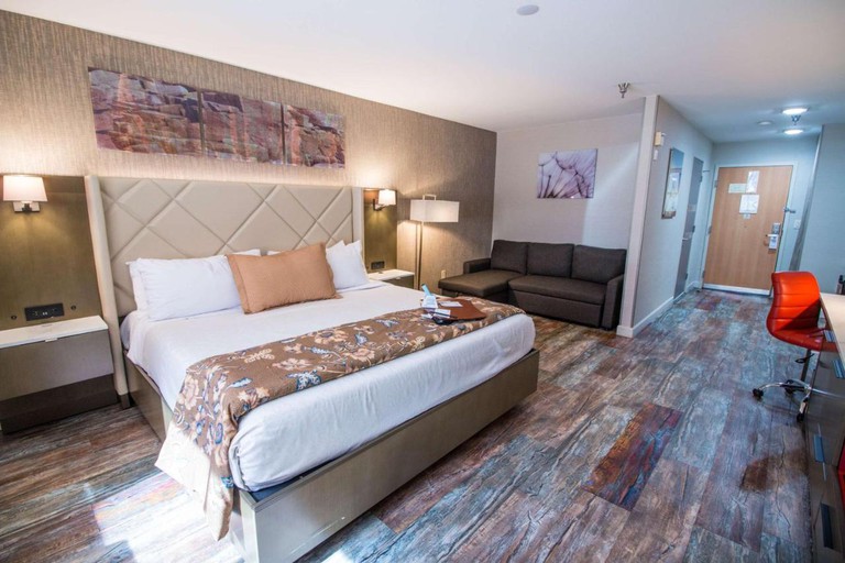 A comfy one-bed guest room with a sofa and abstract art at Empieria High Sierra Hotel