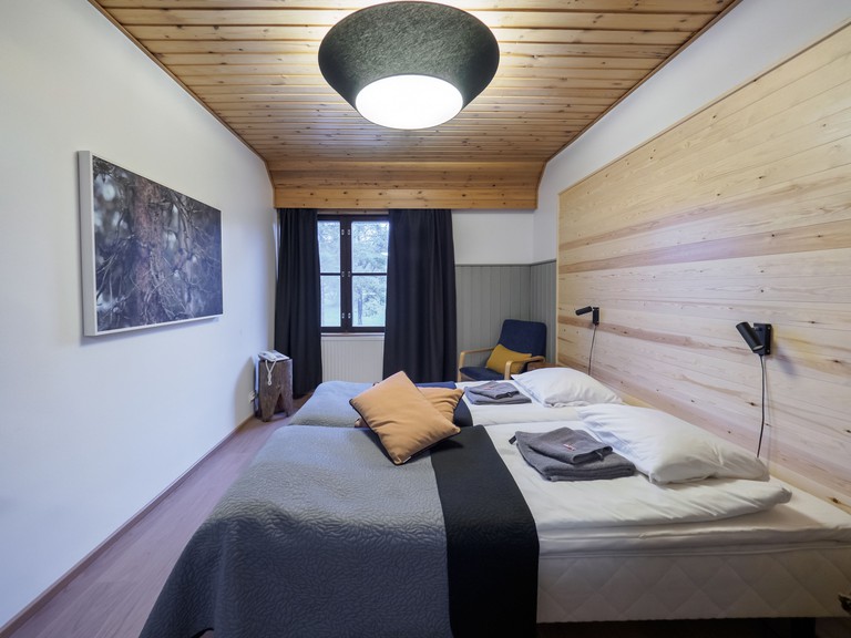 A double room at Fell Centre Kiilopää, Hotel Niilanpää features cosy furnishings and a modern wall headboard