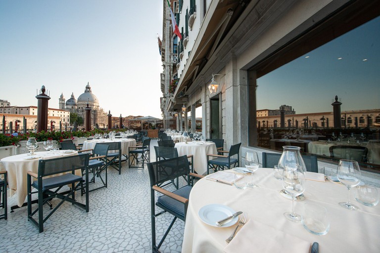 Luxurious outdoor dining space overlooking San Marco Basin at the Hotel Monaco and Grand Canal