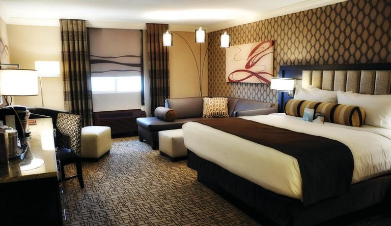 A one-bed guest room in shades of brown and black and with abstract art at the Golden Nugget Las Vegas