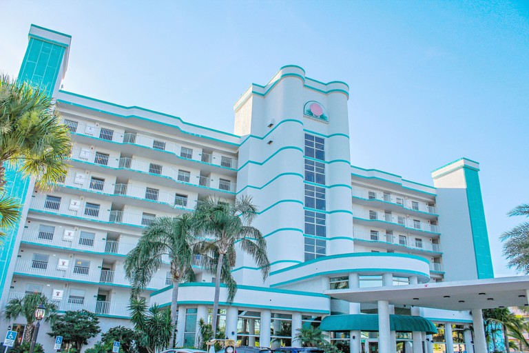 Discovery Beach Resort exterior in classic Florida style with palms and white and blue colorway