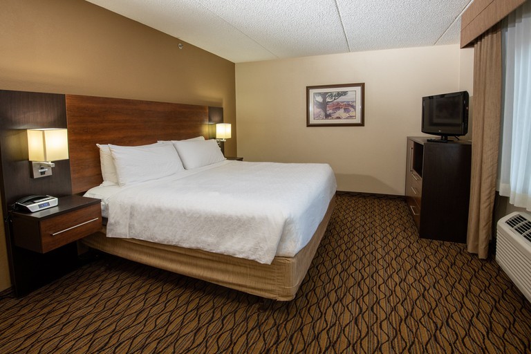 A classic one-bed guest room in shades of brown at the Holiday Inn Express Hotel and Suites Grand Canyon